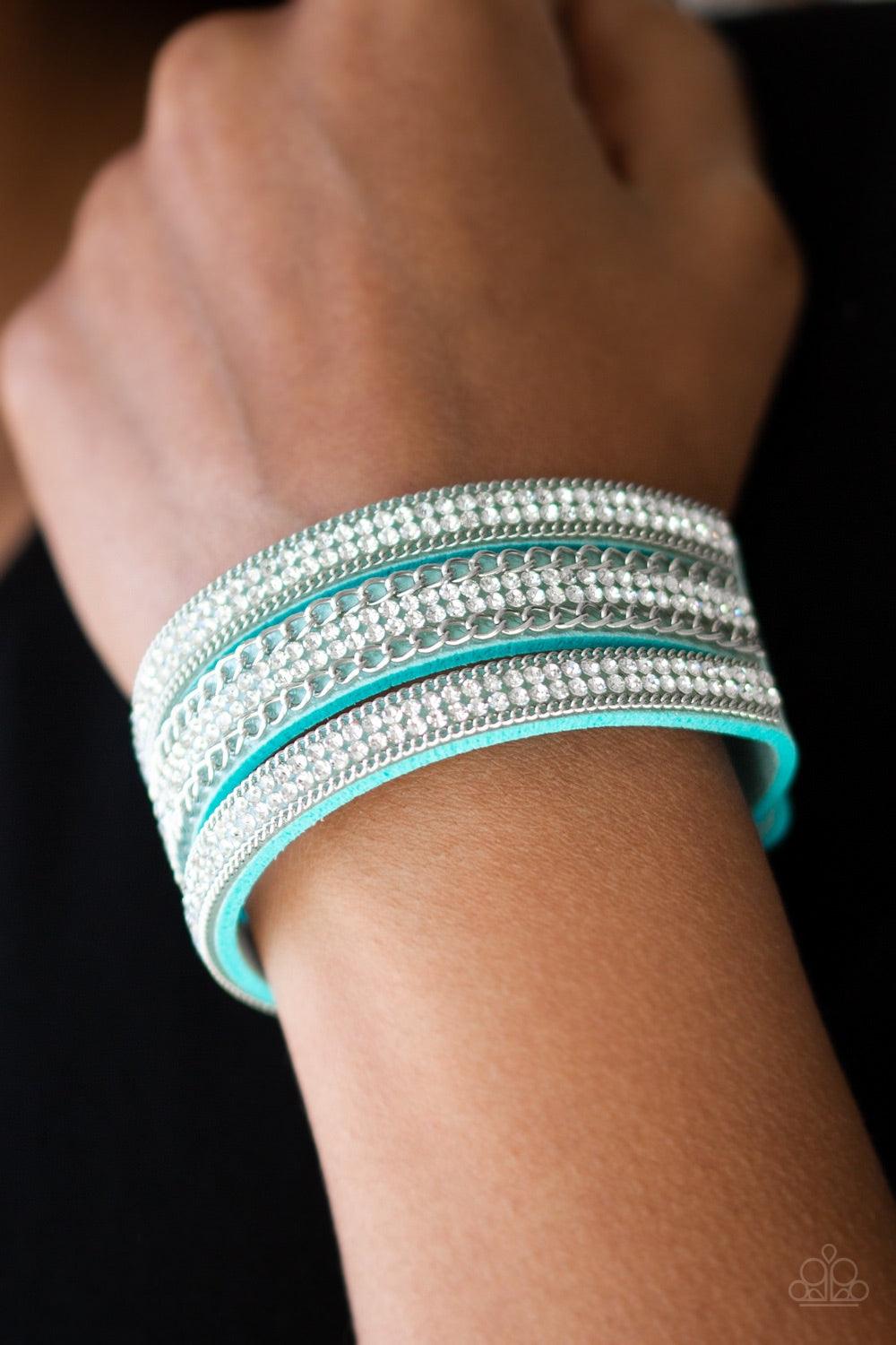 Paparazzi Accessories Dangerously Drama Queen - Blue Rows of shimmery silver chains and glassy white rhinestones are encrusted along a blue suede band. The glittery band has been spliced into three strands, creating row after row of blinding shimmer for a