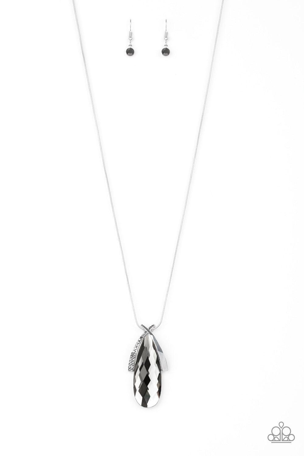 Paparazzi Accessories Stellar Sophistication - Silver A hematite rhinestone encrusted frame and smooth silver frame overlap at the top of a faceted smoky teardrop gem, creating a dramatic pendant. The refined pendant swings from the bottom of a rounded sn
