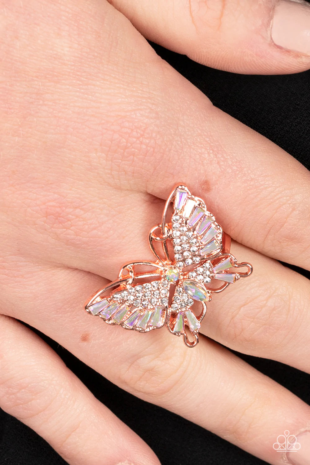 Paparazzi Accessories Fearless Flutter - Copper Sparkling with round, teardrop, and emerald cut white and iridescent rhinestones, a shiny copper butterfly fearlessly flutters atop the finger for a statement-making finish. Features a stretchy band for a fl