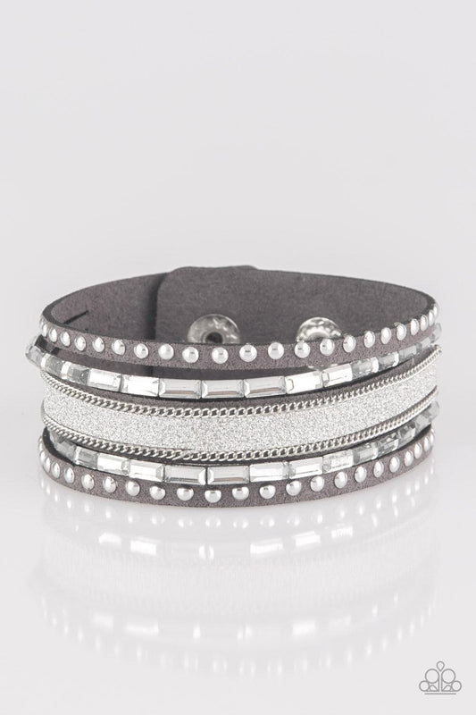 Paparazzi Accessories Seize The Sass - Silver Shimmery silver studs, dainty silver chains, and white emerald style cut rhinestones are encrusted along a gray suede band dusted in a sparkling center for a sassy look. Features an adjustable snap closure. So