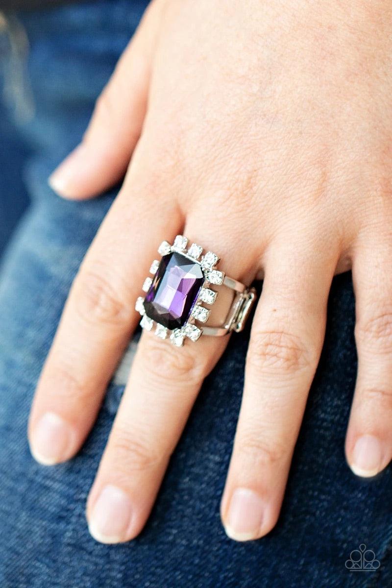 Paparazzi Accessories Galactic Glamour - Purple Featuring dainty silver square fittings, an explosion of glassy white rhinestones fans out from a dramatically oversized emerald cut purple rhinestone center, creating a stellar centerpiece atop the finger.