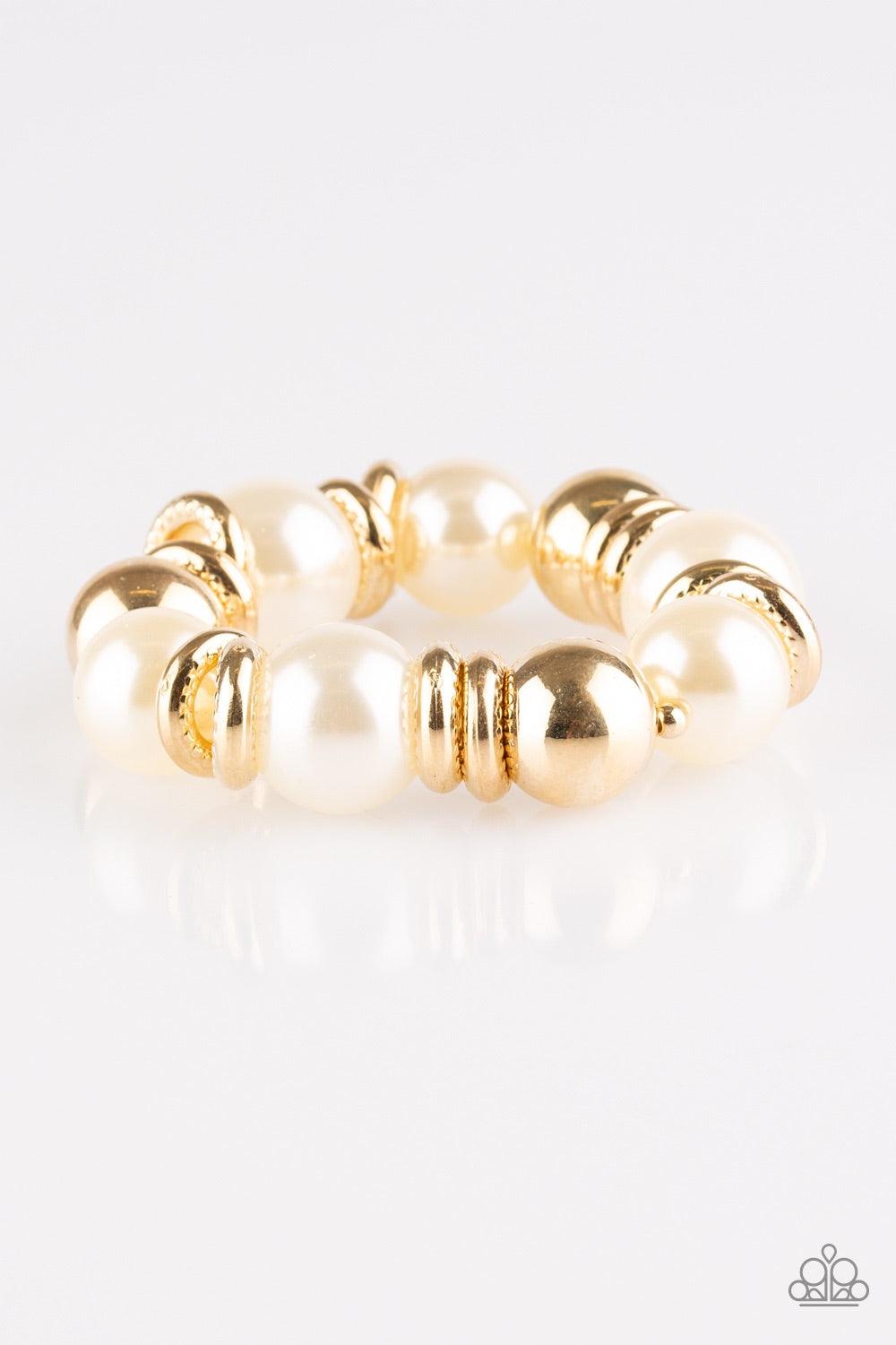 Paparazzi Accessories Rockin Rockefeller - Gold Dramatic white pearls and shiny gold beads are threaded along an elastic stretchy band around the wrist. Glistening gold accents are sprinkled between the classic beads, adding depth and shimmer to the bubbl