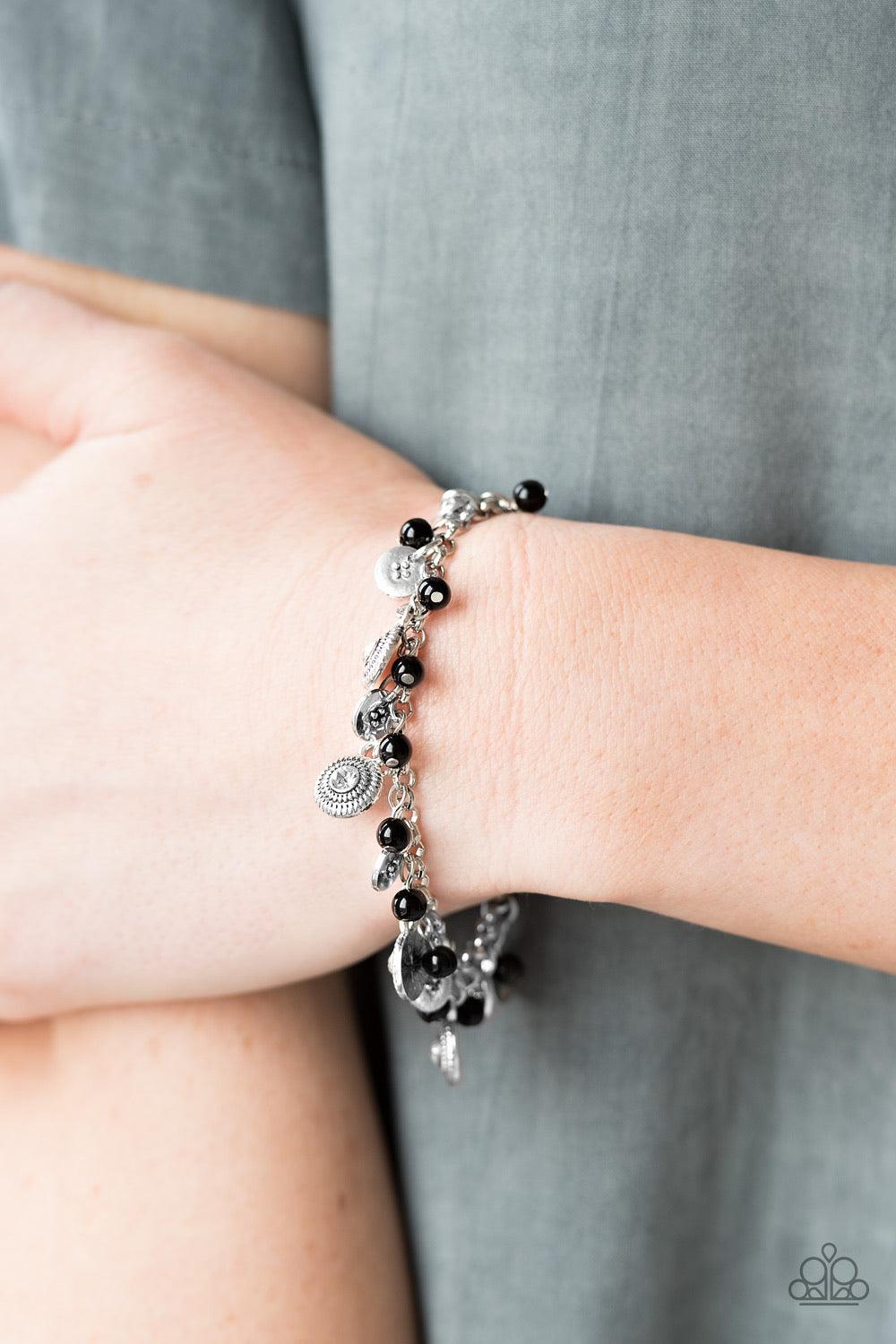 Paparazzi Accessories Pure LUXE - Black Dainty black beads and ornate silver discs swing from a shimmery silver chain, creating a casual fringe around the wrist. Featuring rhinestone centers, textured silver discs are sprinkled between refined beading for