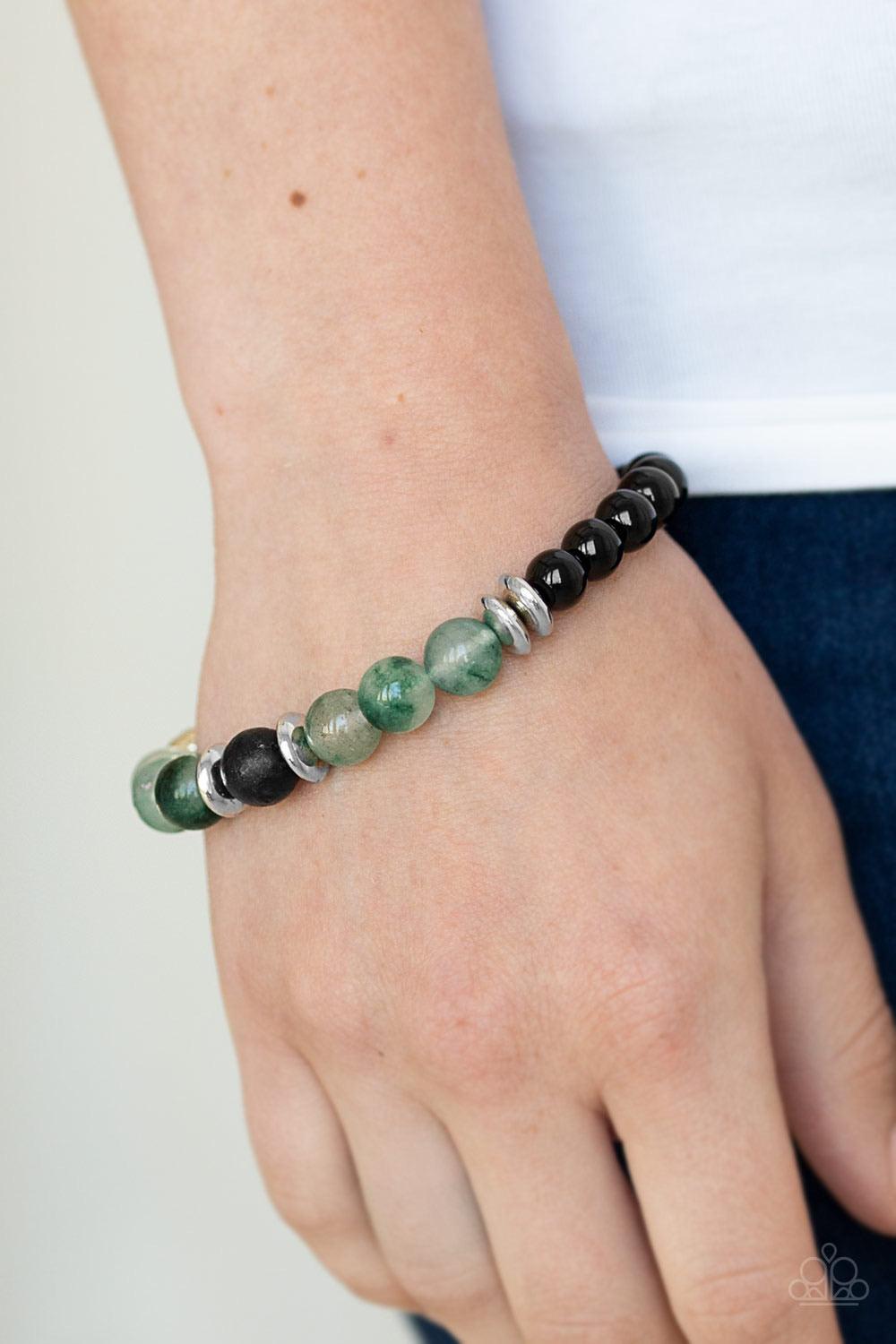 Paparazzi Accessories World Peace - Green An earthy assortment of shiny black beads, glassy green stone beads, glistening silver accents, and a single black lava rock bead are threaded along a stretchy band around the wrist for a refreshing look. Sold as
