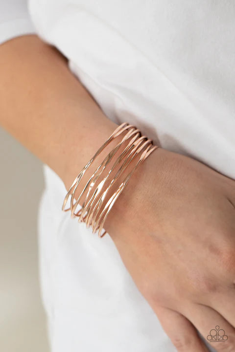 Paparazzi Accessories Nerves Of Steel - Rose Gold Featuring sections of flattened surfaces, glistening rose gold wires crisscross across the wrist, coalescing into an intense industrial cuff. Sold as one individual bracelet. Jewelry