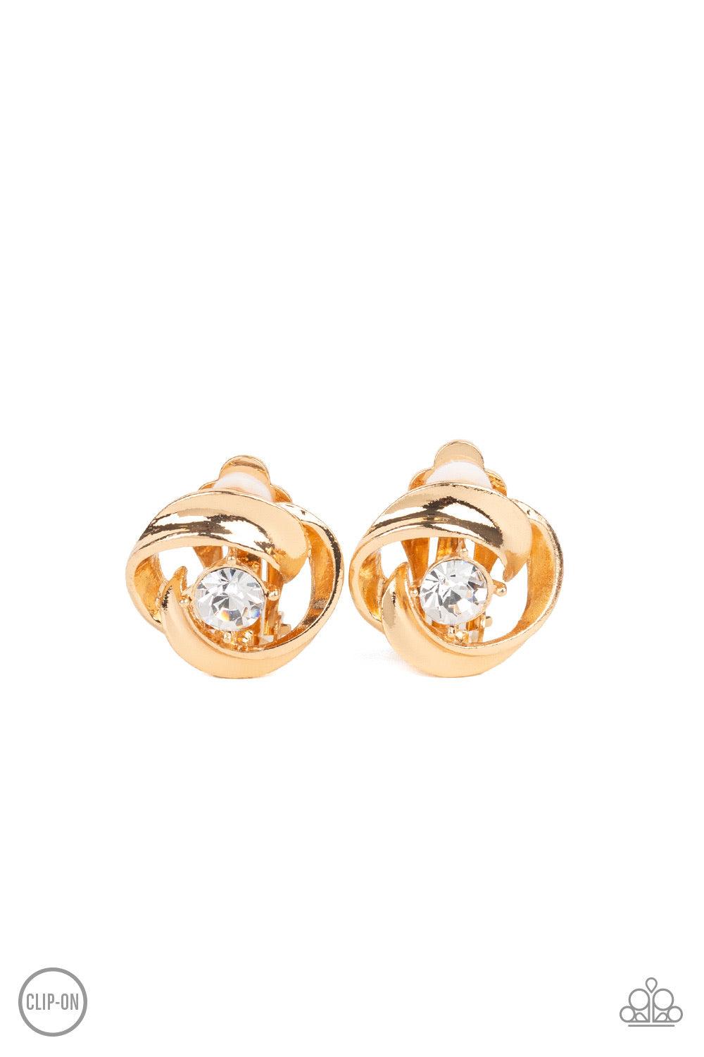 Paparazzi Accessories Girl Whirl - Gold *Clip-On Glistening gold ribbons whirl around a dainty white rhinestone center, coalescing into a refined frame. Earring attaches to a standard clip-on fitting. Jewelry
