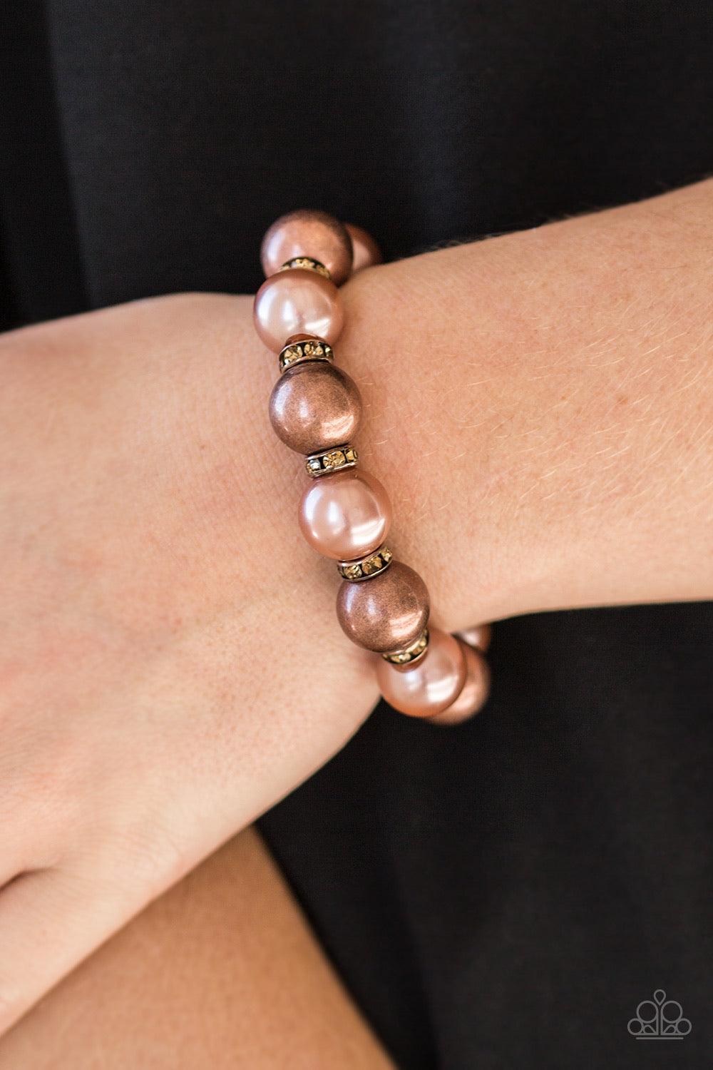 Paparazzi Accessories So Not Sorry - Copper A collection of topaz rhinestone encrusted rings, pearly copper beads, and classic copper beads are threaded along a stretchy band around the wrist for a glamorous look. Jewelry