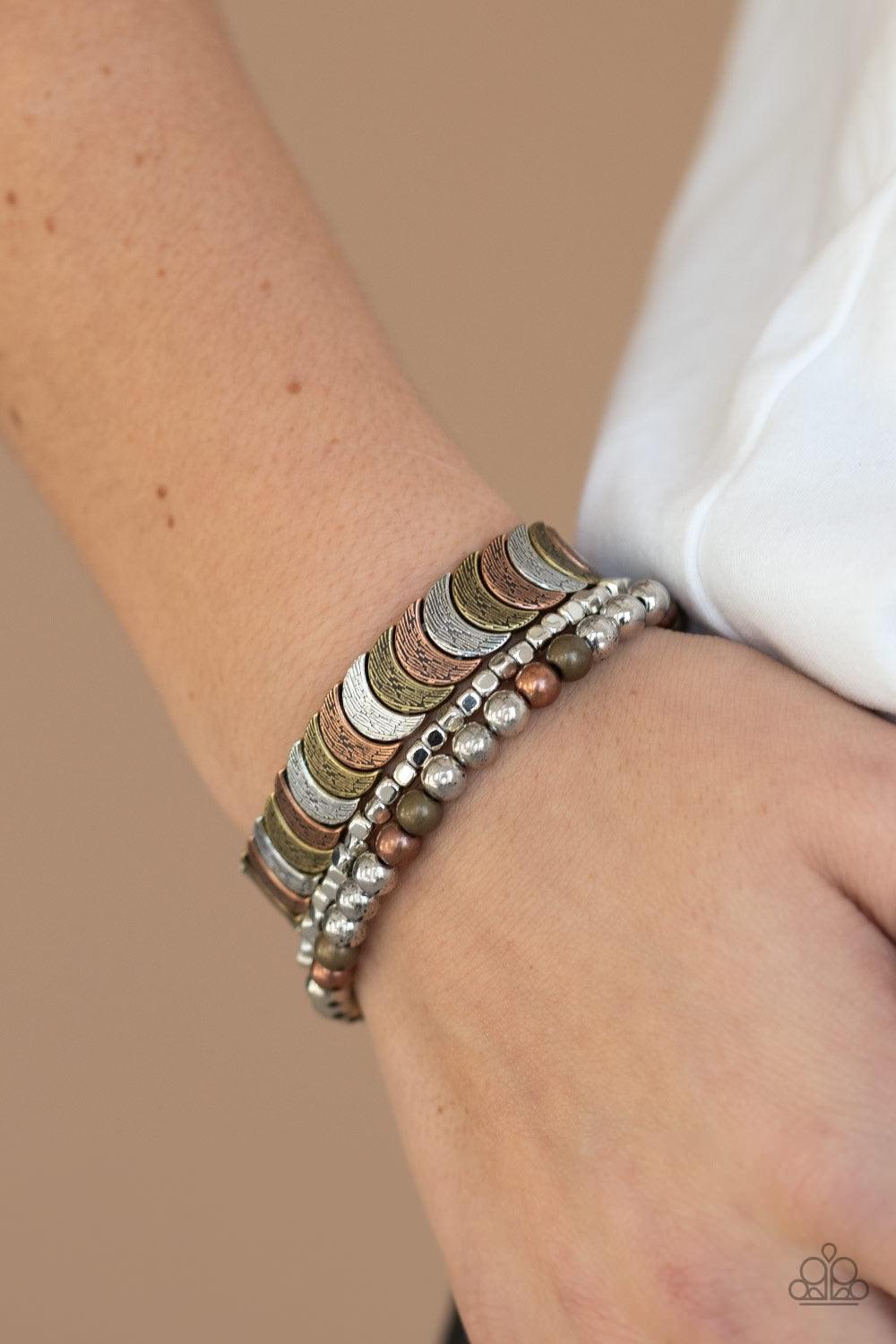 Paparazzi Accessories LAYER It On Me - Multi Featuring round, cube, and half-moon shapes, mismatched brass, copper, and silver beads are threaded along stretchy bands, creating trendy mixed metallic layers around the wr Jewelry