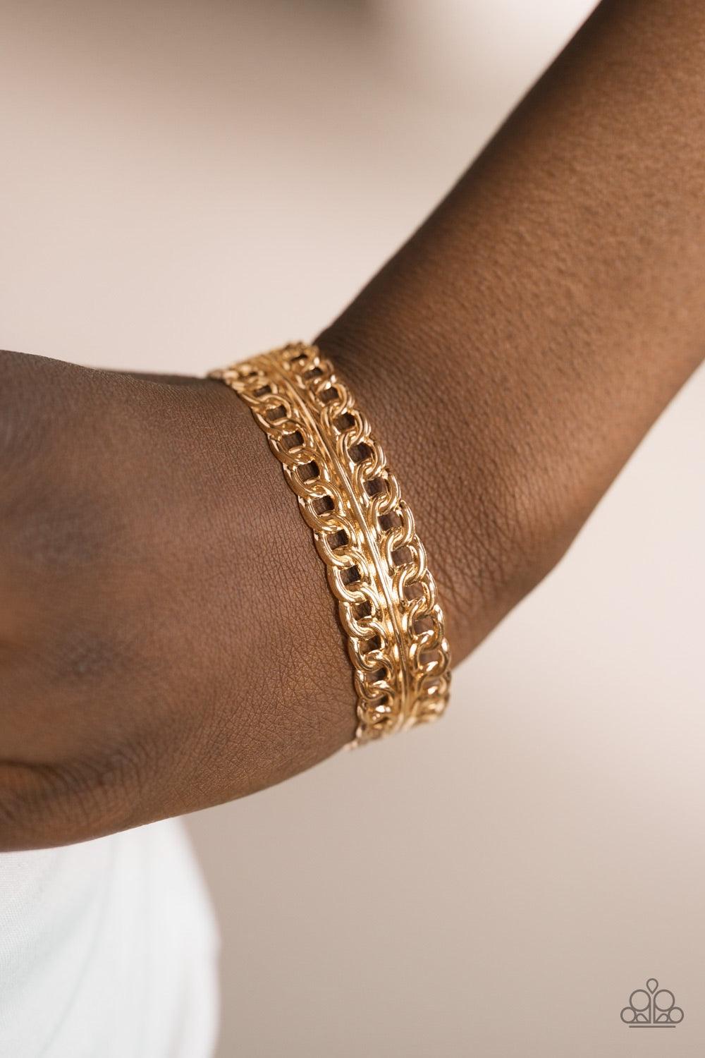 Paparazzi Accessories Progressive Movement - Gold Glistening rows of silver chain link stack across the wrist, coalescing into a bold industrial cuff. Jewelry