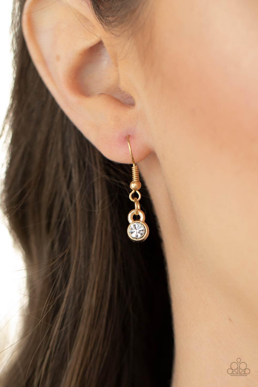 Paparazzi Accessories Sphere of Influence - Gold A solid gold ring entwines with a brilliant white rhinestone encrusted ring. The pair of rings rest in a gold hoop on a short round gold chain. Features an adjustable clasp closure. Sold as one individual n