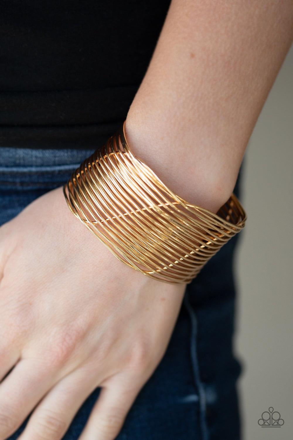Paparazzi Accessories Retro Revamp - Gold A glistening gold wire weaves through stacked gold bars arcing across the wrist, coalescing into an edgy cuff. Sold as one individual bracelet. Jewelry