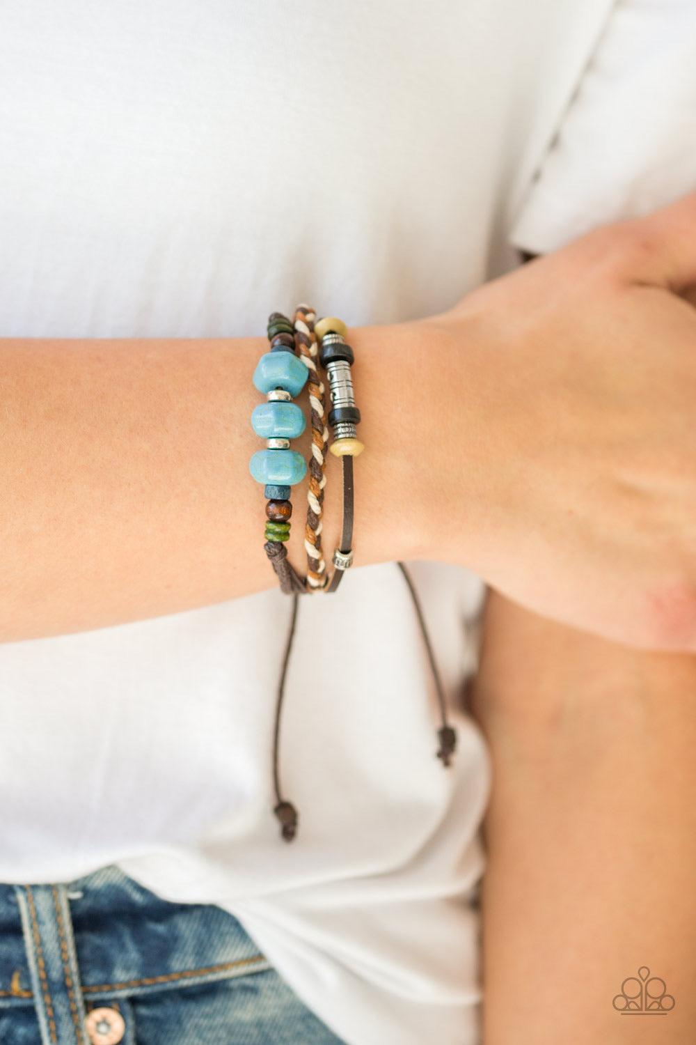 Paparazzi Accessories Catch Me CLIFF You Can - Blue Refreshing turquoise stones, colorful wooden beads, and metallic accents are knotted along mismatched leather and corded bands for a seasonal look. Features an adjustable sliding knot closure. Jewelry