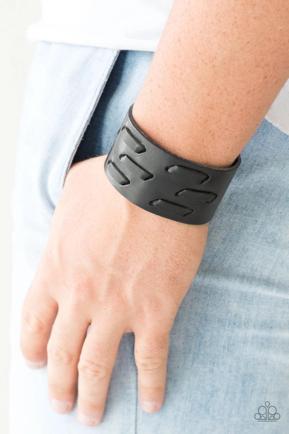 Paparazzi Accessories Be Your Own Huntsman - Black Black leather cording is laced across the front of a thick leather band, creating a rugged look around the wrist. Features an adjustable snap closure.Sold as one individual bracelet. Jewelry