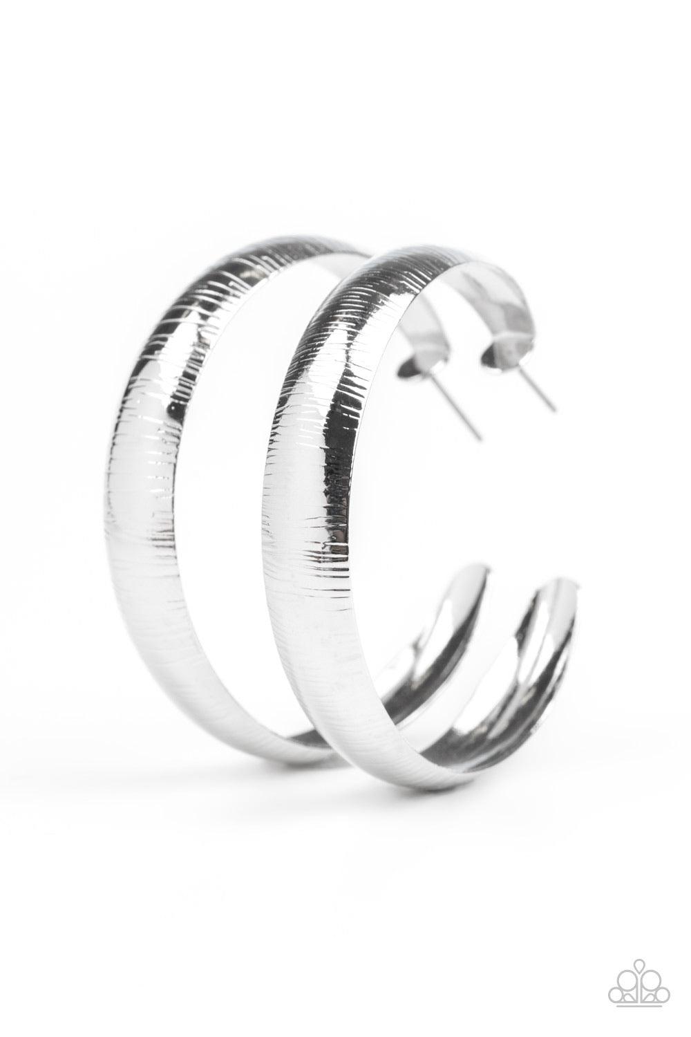 Paparazzi Accessories Hoop Wild - Silver Etched in a shimmery linear pattern, a thick silver hoop curls around the ear for some classic edge. Earring attaches to a standard post fitting. Hoop measures approximately 2" in diameter. Jewelry