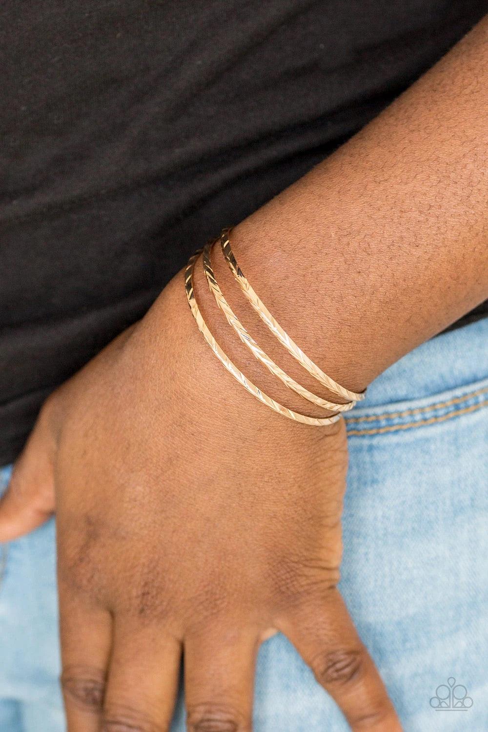 Paparazzi Accessories Eastern Empire - Gold Etched in shimmery geometric patterns, glistening gold bars arc across the wrist, coalescing into a dainty cuff. Sold as one individual bracelet. Jewelry