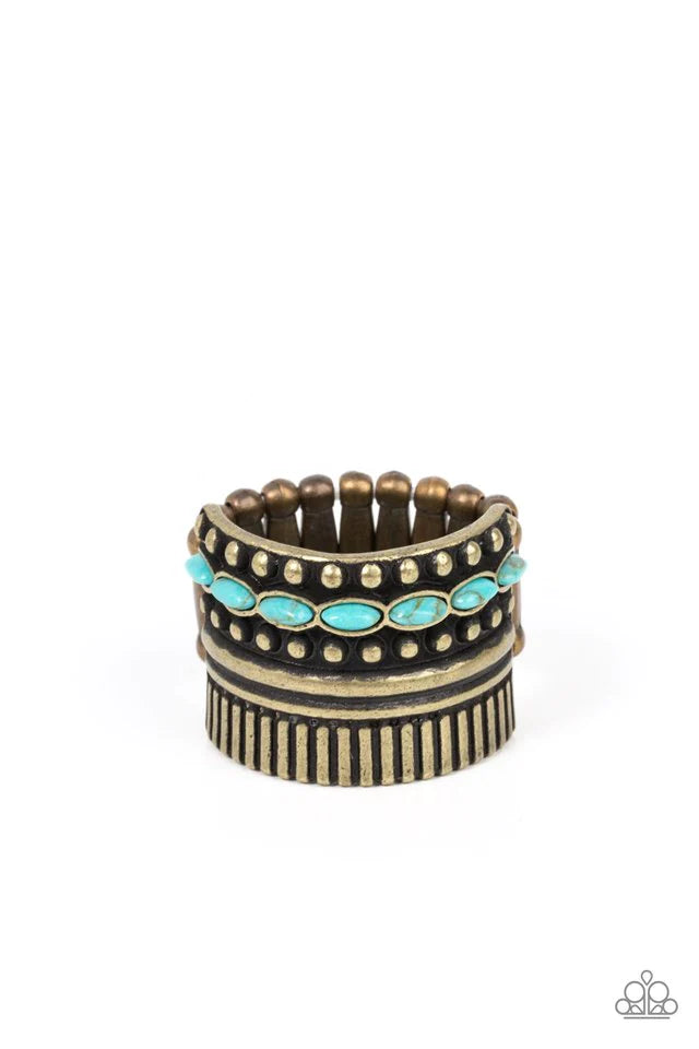 Paparazzi Accessories Local Flavor - Brass A wide brass band is overlaid with layers of linear texture, smooth brass bars, and antiqued studs. A row of dainty oval shaped turquoise stones flows across the band, adding a splash of color atop the finger. Fe