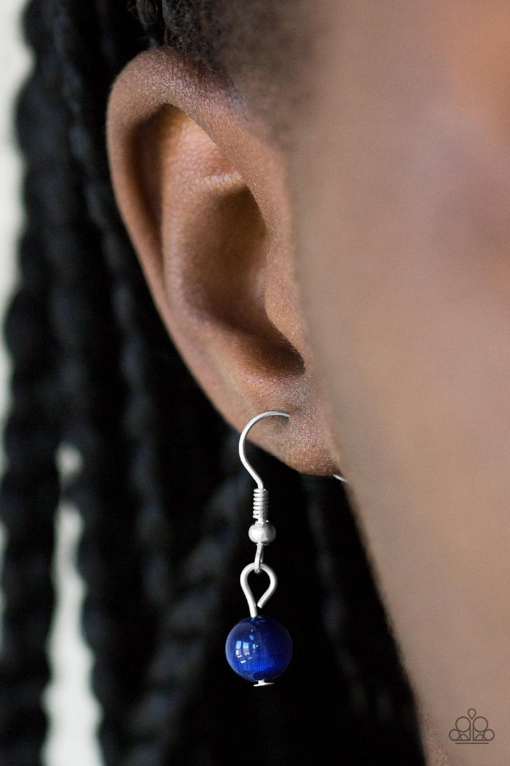 Paparazzi Accessories Nightcap And Gown - Blue Sporadically dotted in glittery white rhinestones, dainty silver circles join around the top of a glassy blue teardrop moonstone. The bubbly pendant swings from the bottom of a lengthened silver chain for a w