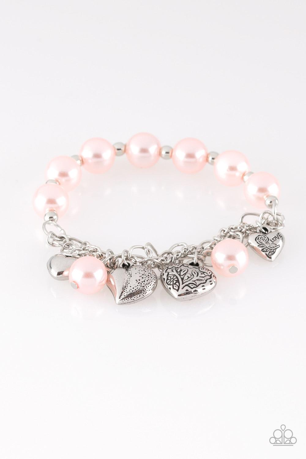 Paparazzi Accessories More Amour - Pink Attached to a section of shimmery silver chain, pearly pink and dainty silver beads are threaded along a stretchy band. Mismatched silver heart charms swing from the glistening chain, creating a flirty fringe. Jewel