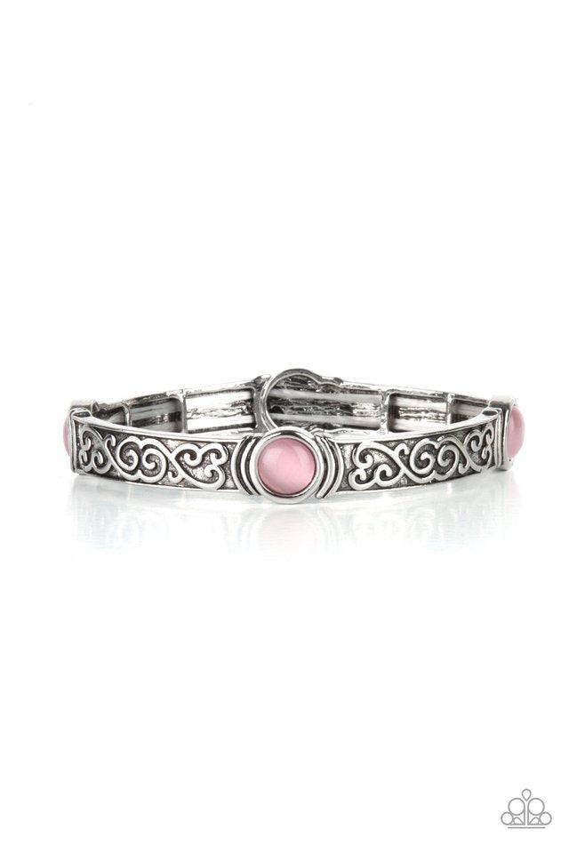 Paparazzi Accessories Ethereally Enchanting -Pink A pink cat's eye stone is pressed into a round frame at the end of a silver bar. Embossed with a whimsical vine motif, the patterned bars are threaded on stretchy bands to repeat around the wrist for an en