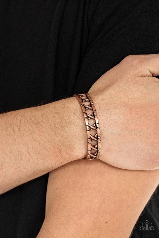 Paparazzi Accessories In Over Your METALHEAD - Copper Asymmetrical bars crisscross inside the airy center of a rustic copper cuff, creating an edgy display around the wrist. Jewelry