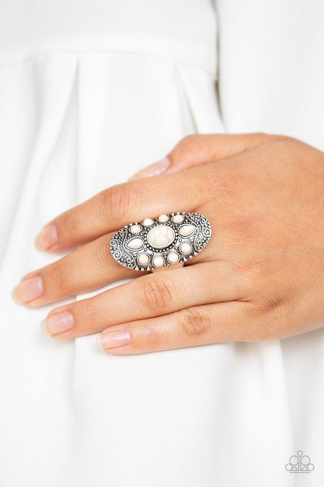Paparazzi Accessories Stone Sunrise - White Embossed in a studded filigree pattern, an oval silver frame folds around the finger. Featuring round, oval, and teardrop shapes, refreshing white stone beads are pressed into the center of the frame, creating a