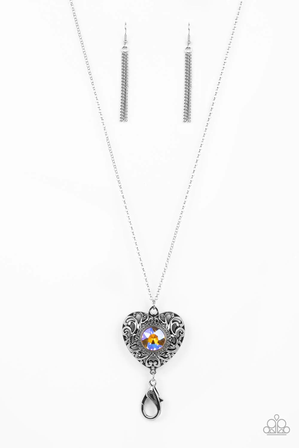 Paparazzi Accessories Prismatic Passion - Multi *Lanyard A magical iridescent peach gem sparkles at the center of a 3-dimensional silver heart. Filled with vine-like filigree, the locket-inspired heart pendant glides along an extended silver chain while a