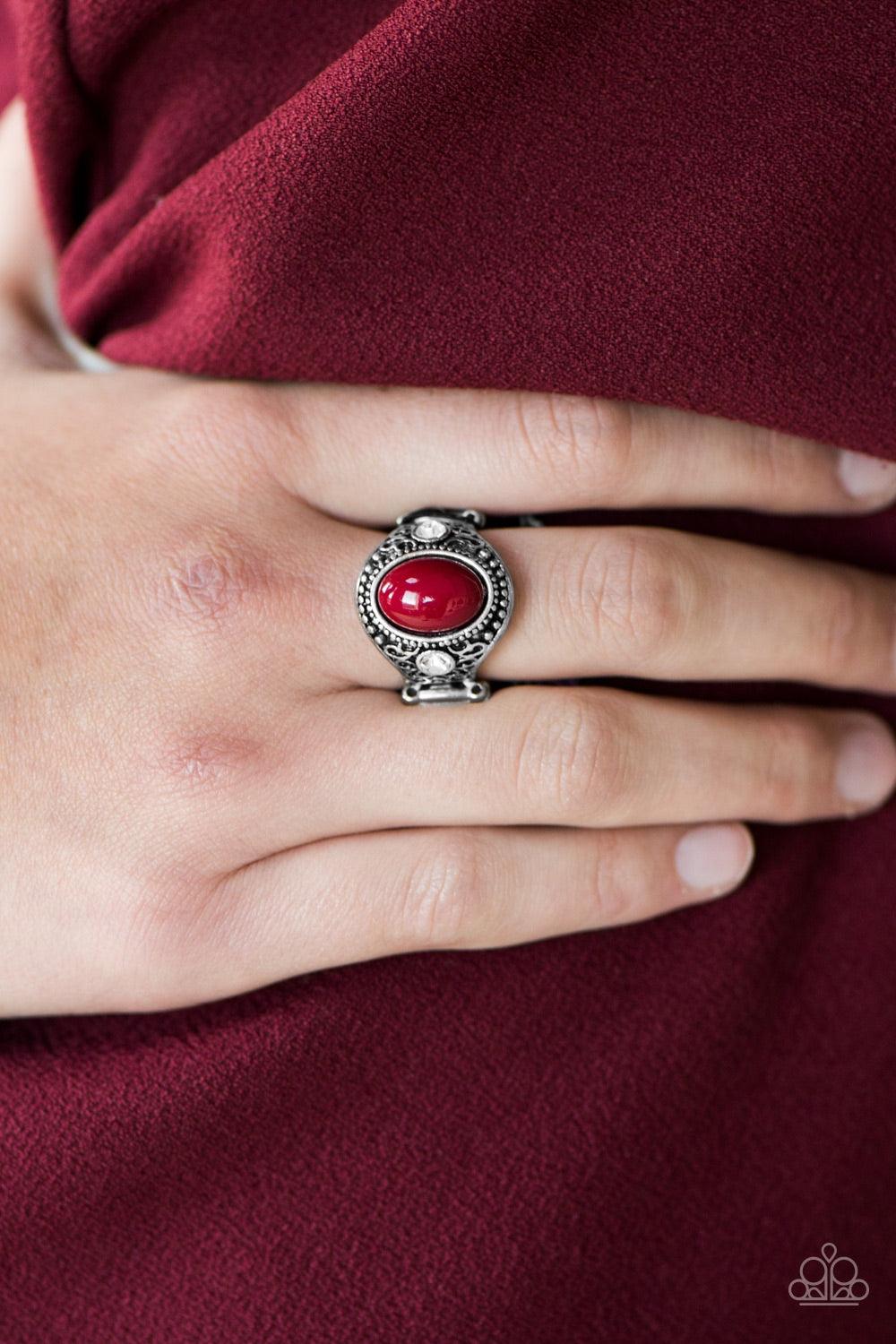 Paparazzi Accessories Beautifully Bali - Red Brushed in an antiqued shimmer, frilly filigree climbs the finger, coalescing into a vintage inspired frame. Flanked by glittery white rhinestones, a red bead is pressed into the center of the frame for a color