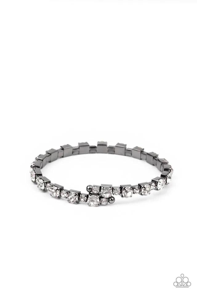 Paparazzi Accessories Photo Op - Black Featuring gunmetal square fittings, dainty and classic white rhinestones delicately alternate along a flexible wire, coiling into a glamorous centerpiece around the wrist. Jewelry