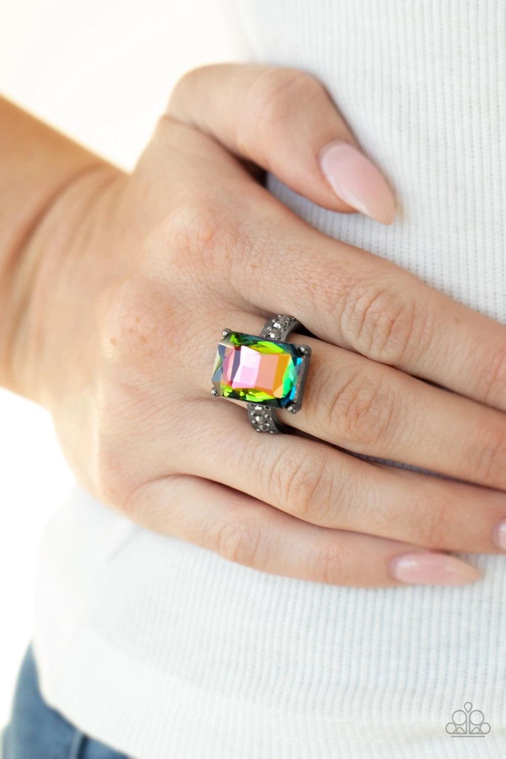 Paparazzi Accessories Bring Down The POWERHOUSE - Multi Featuring an elegant emerald-style cut, an oversized oil spill gem is pressed into the center of a dainty gunmetal band dotted in glassy hematite rhinestones for a show-stopping sparkle. Features a d