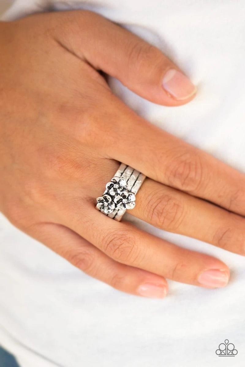 Paparazzi Accessories This ISLAND Is Your ISLAND - Silver A trio of flowers bloom from the center of a thick silver band rippling with hammered and linear textures for a seasonal look. Features a stretchy band for a flexible fit. Sold as one individual ri