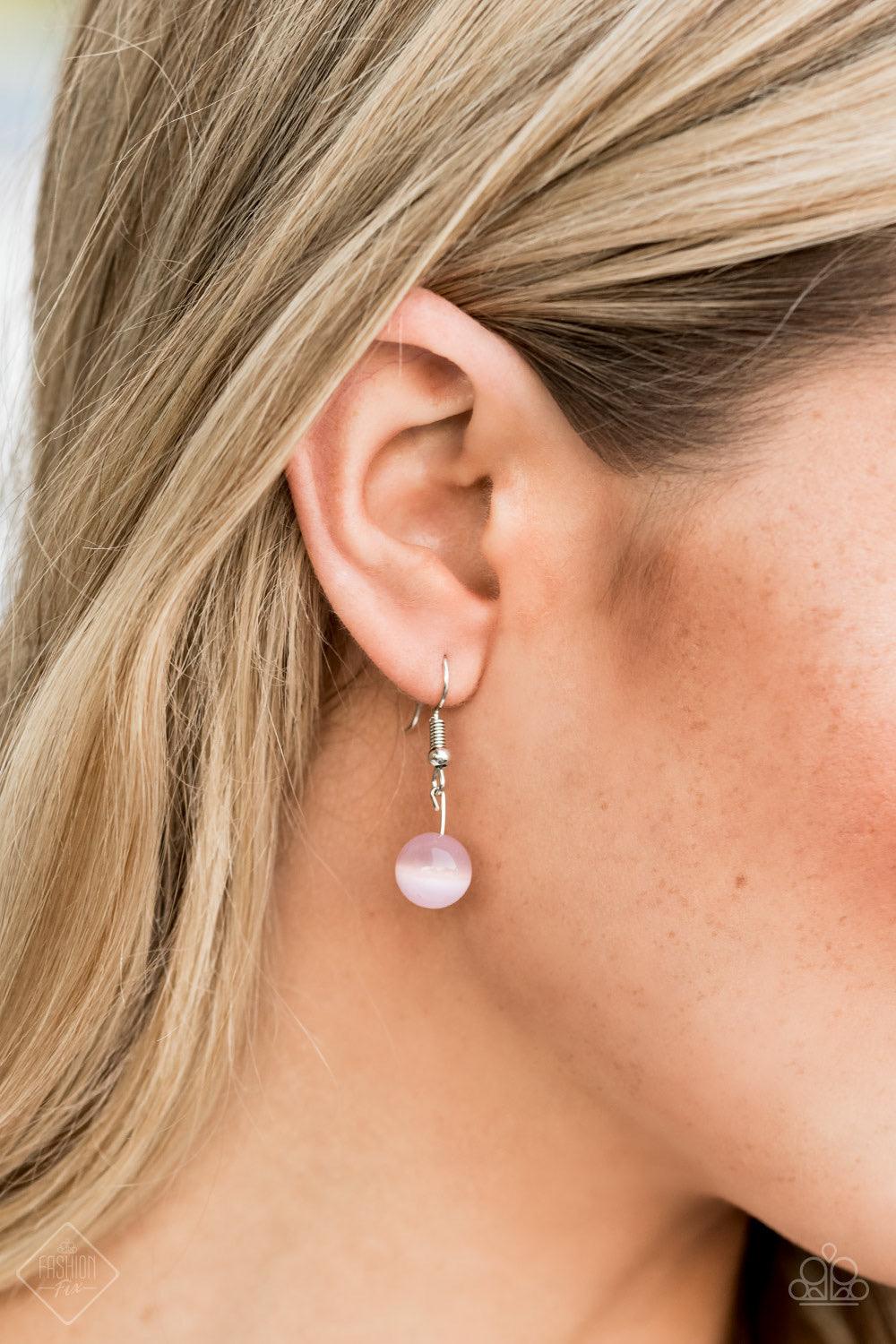 Paparazzi Accessories Tasseled Tranquility - Pink An oversized pink cat's eye stone frame gives way to a shimmery silver chain tassel, creating a whimsically stacked pendant at the bottom of a lengthened silver chain. Features an adjustable clasp closure.