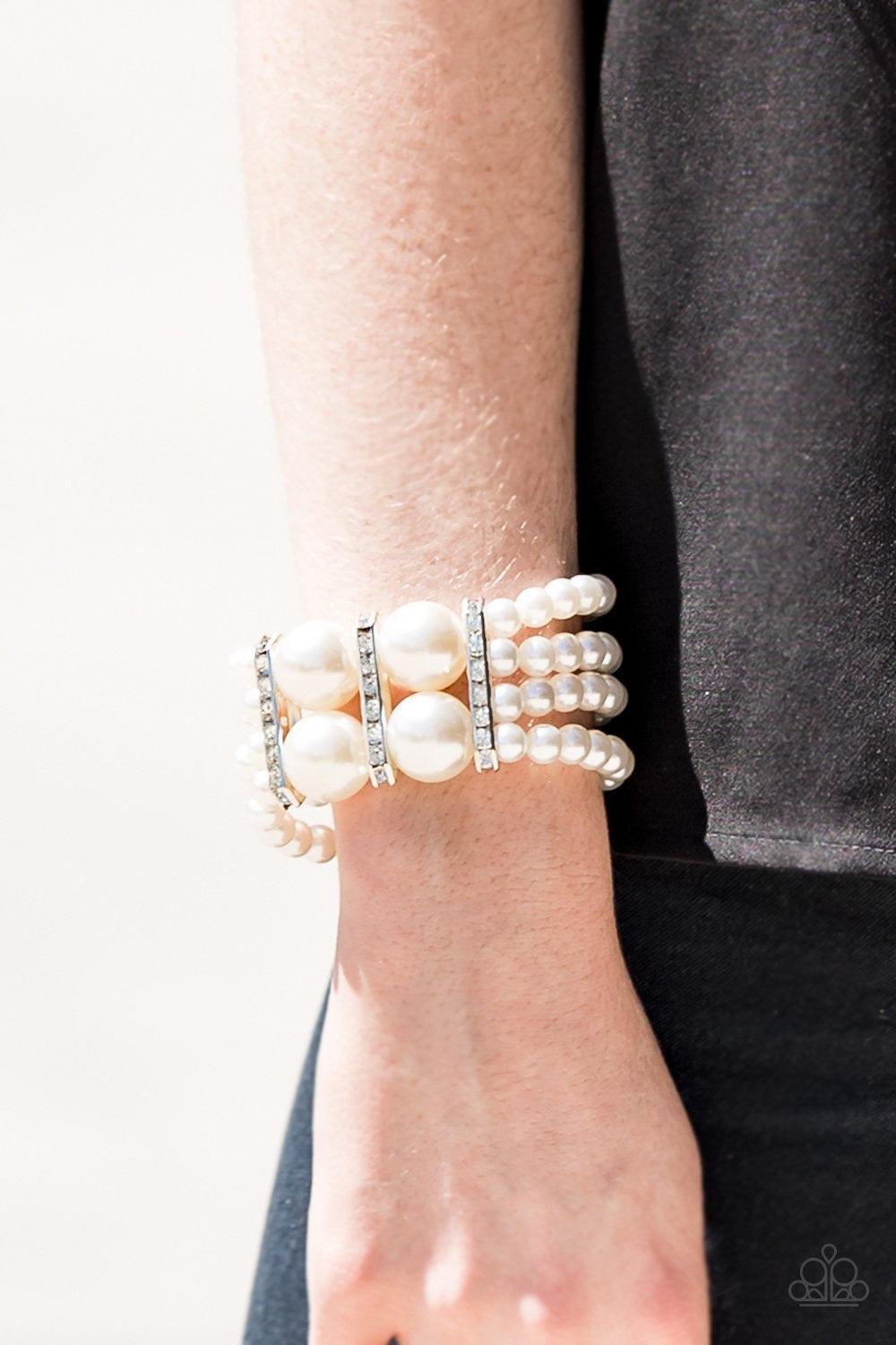 Paparazzi Accessories Romance Remix - White Strands of shiny white beads are threaded along stretchy elastic bands and joined together by white rhinestone encrusted frames. The glittery frames combine with oversized beads at the center, adding a dramatic