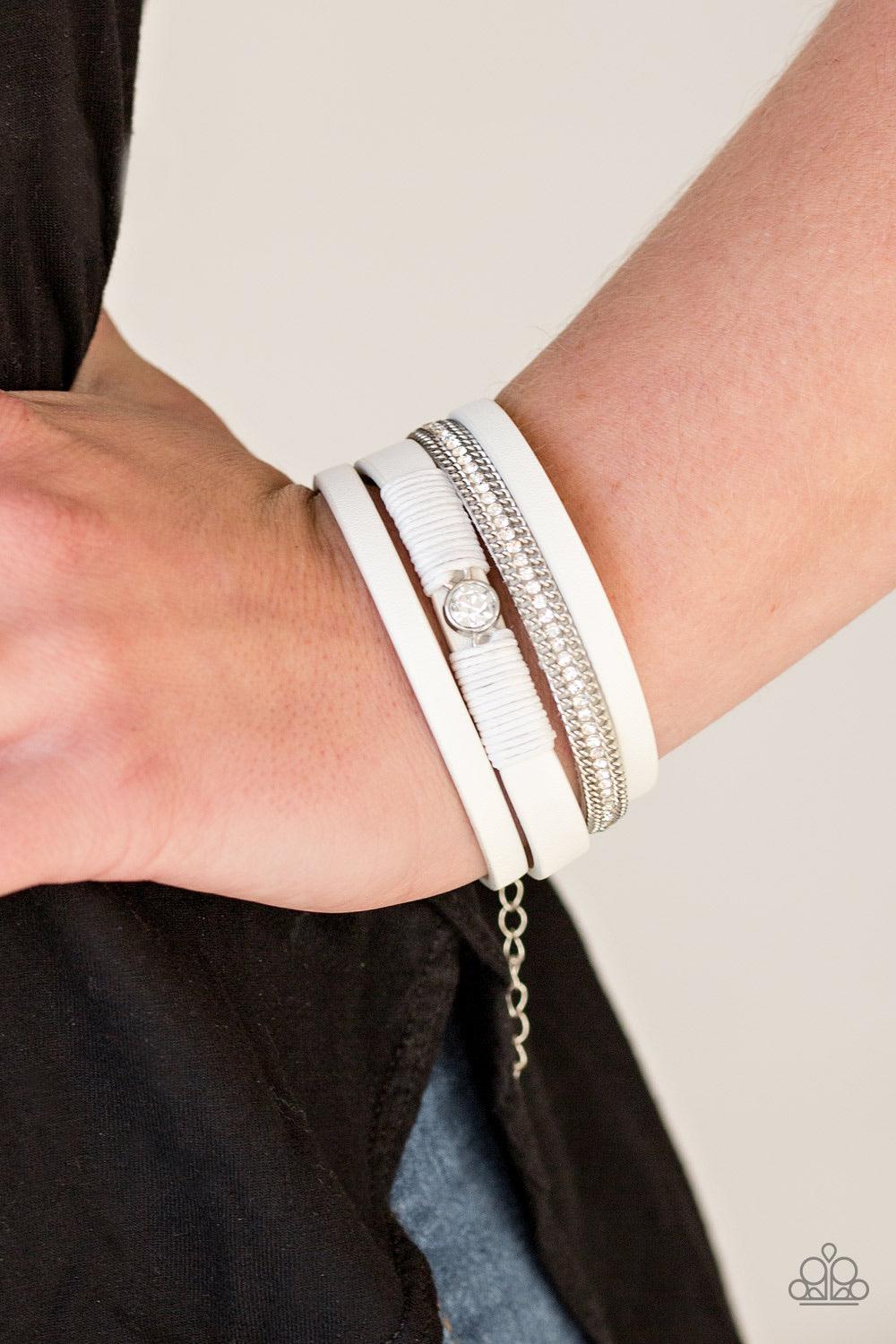 Paparazzi Accessories Catwalk Craze - White White leather strands layer across the wrist. Infused with silver chain and white rhinestone accents, white cording knots around a leather strand, securing a solitaire white rhinestone in place for a whimsical f