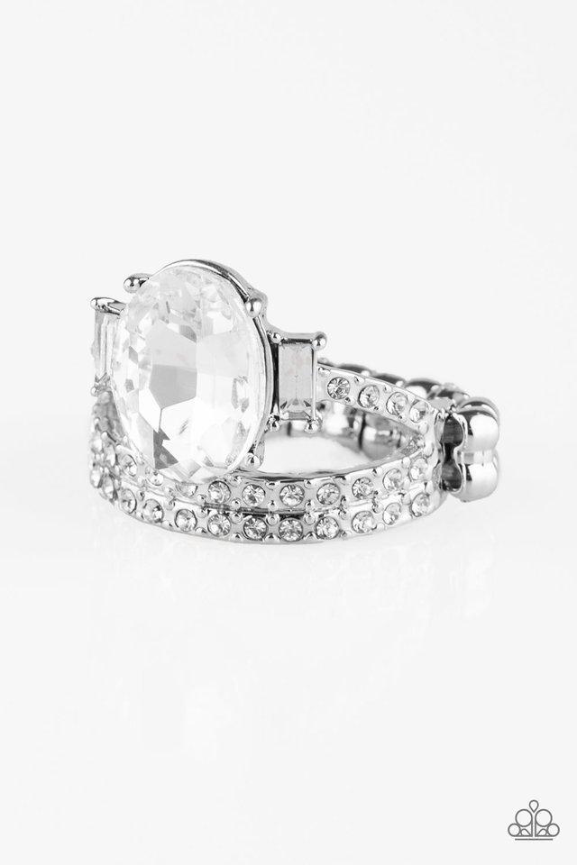 Paparazzi Accessories Bling Queen - White Encrusted in glassy white rhinestones, shiny silver bands arc across the finger. Infused with emerald style rhinestones, an over sized white rhinestone crowns the layered bands for a regal finish. Features a daint