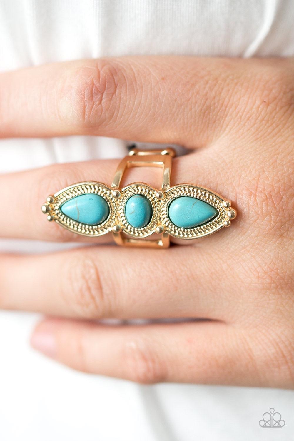 Paparazzi Accessories Calling All Chiefs - Gold Refreshing turquoise stone beads are pressed into an elongated gold frame. Dotted with gold studs and embossed in stunning rope-like textures, the dramatic frame extends down the finger in a simply seasonal