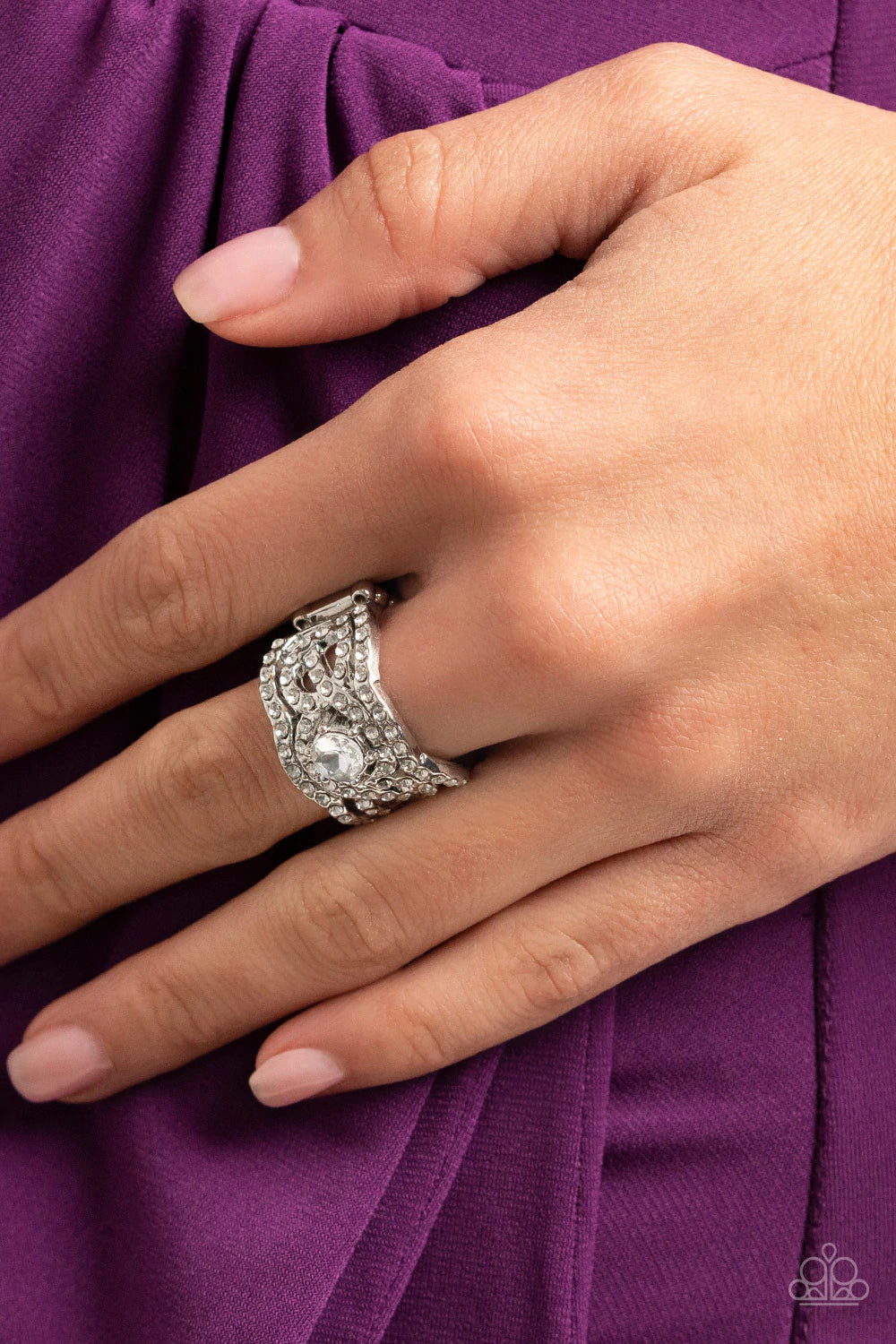 Paparazzi Accessories Doting On Dazzle - White Wavy scalloped rows encased with rhinestones are topped by a central, sparkling rhinestone to provide an elegant and timeless look. Features a stretchy band for a flexible fit. Sold as one individual ring. Je