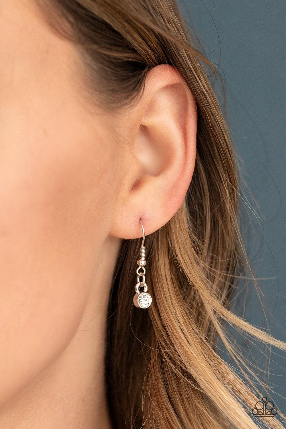 Paparazzi Accessories Sassy As They Come - White A large rounded rhinestone dangles above a glistening white rhinestone encrusted ring which swings from the bottom of a lengthened silver chain, creating a glamorous pendant. Rounded silver snake chains str