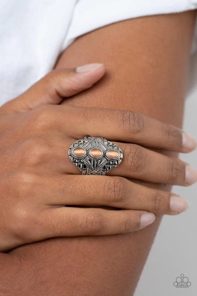 Paparazzi Accessories Eye-Catching Cat’s Eye - Orange Three oval orange cat's eye stones vertically stack down the center of an antiqued silver frame embossed in geometric detail, invoking a tribal inspired fashion. Features a stretchy band for a flexible