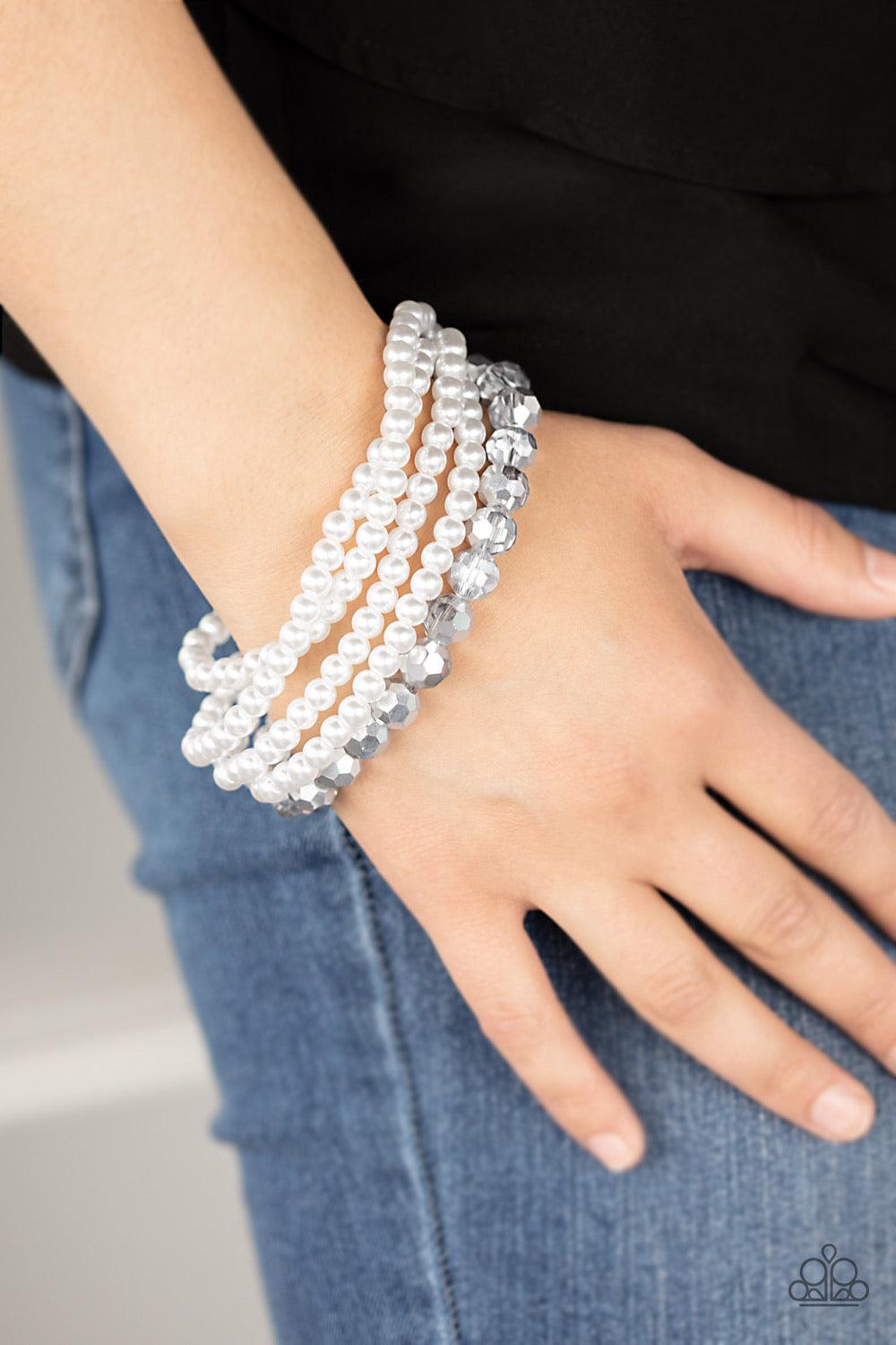Paparazzi Accessories Refined Renegade - White Strands of classic white pearls and metallic crystal-like beads are threaded along an invisible wire around the wrist, creating refined layers. Features an adjustable clasp closure. Sold as one individual bra