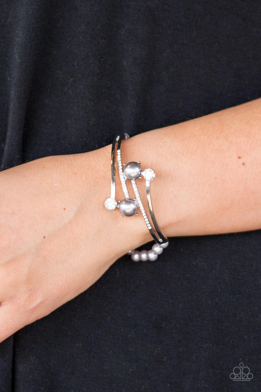 Paparazzi Accessories Can Only Go UPSCALE - Silver Encrusted in glittery white rhinestones, shimmery silver bars crisscross across the wrist. Dotted with pearly silver and sparkling white rhinestone fittings, the elegant centerpiece attaches to a stretchy
