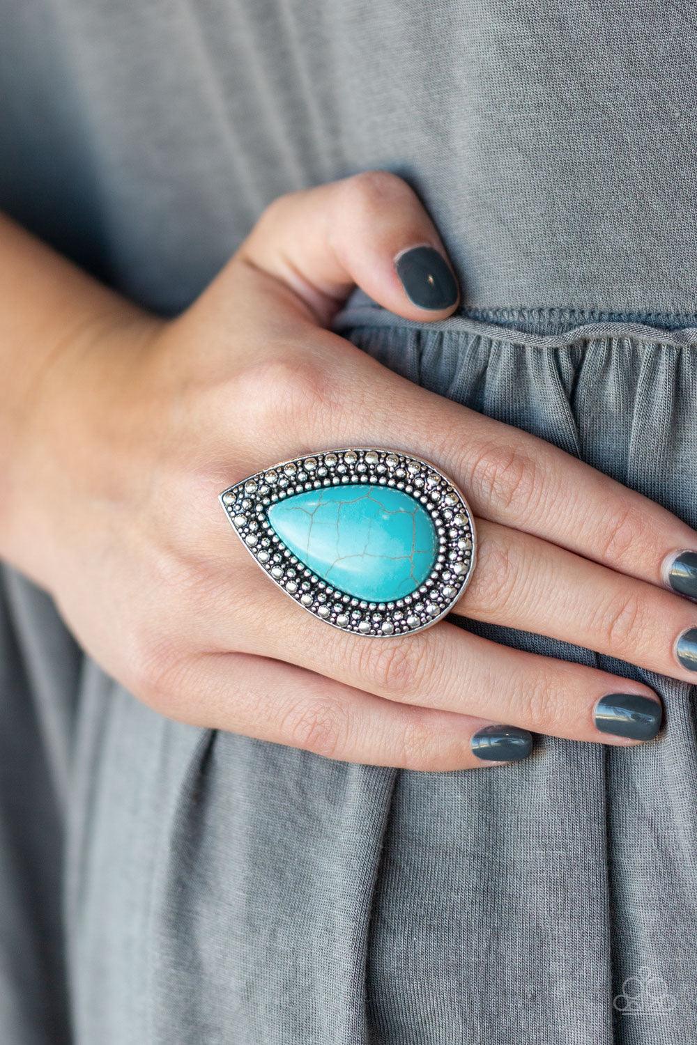 Paparazzi Accessories Santa Fe Storm - Blue Chiseled into a tranquil teardrop, an oversized turquoise stone is pressed into the center of a shimmery silver frame dotted with radiant studded texture for a dramatic stone look. Features a stretchy band for a