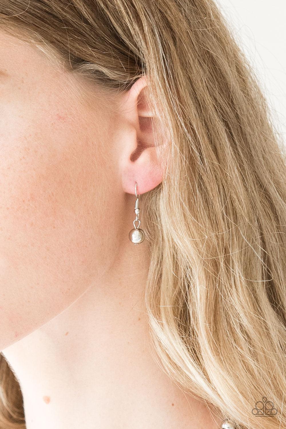 Paparazzi Accessories High-Stakes Fame - Silver Gradually increasing in size near the center, glistening silver beads are threaded along an invisible wire below the collar. Encrusted in smoky rhinestones, a sparkling silver bead adorns the center for a re