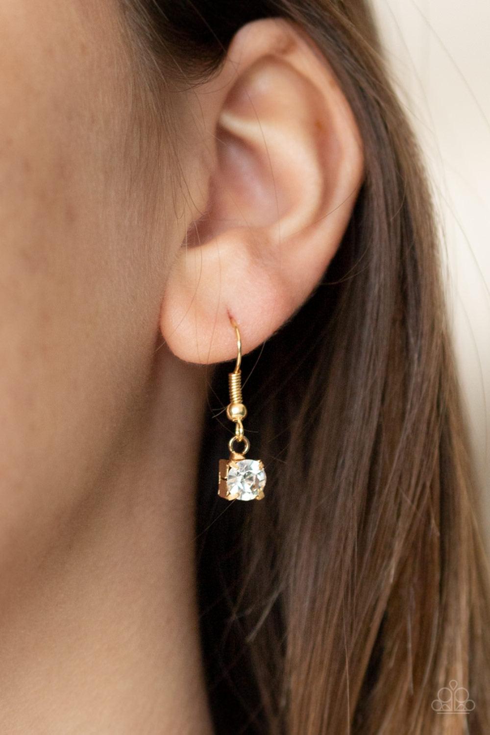 Paparazzi Accessories Inner STARLIGHT - Gold Featuring square gold fittings, a dainty strand of glassy white rhinestones drapes around the neck. The glittery strands delicately connect, splitting off into two twinkling tassels down the chest. Features an