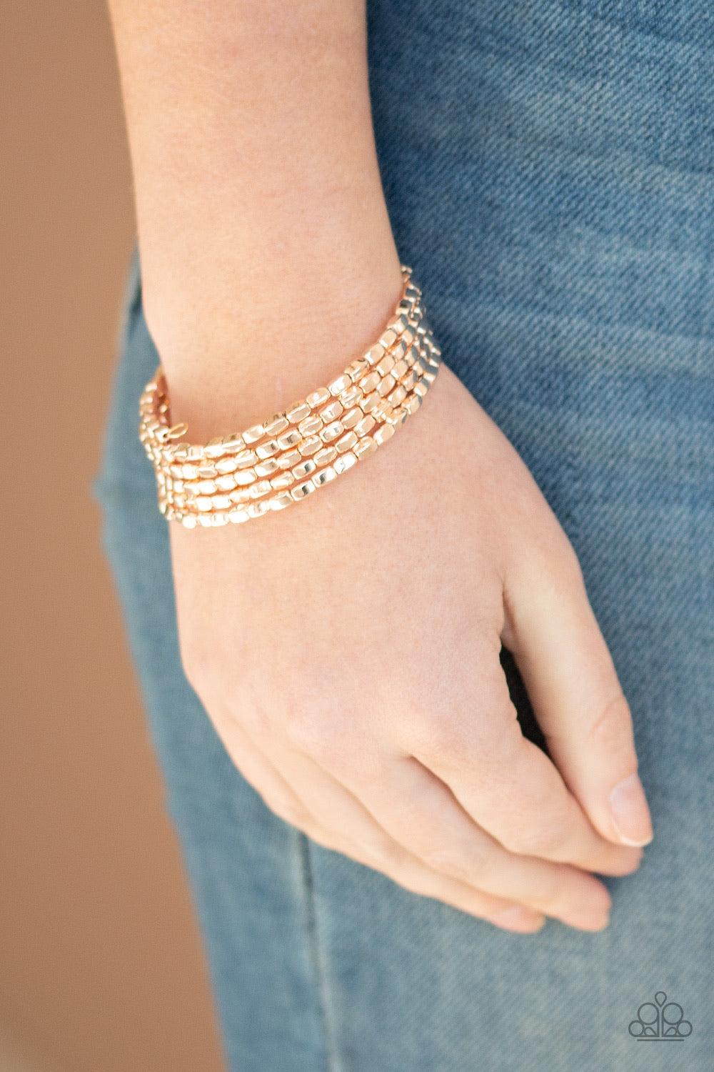 Paparazzi Accessories Stunningly Stacked - Rose Gold A glistening collection of rectangular rose gold beads are threaded along a coiled wire, creating a shimmery infinity wrap style bracelet around the wrist. Jewelry