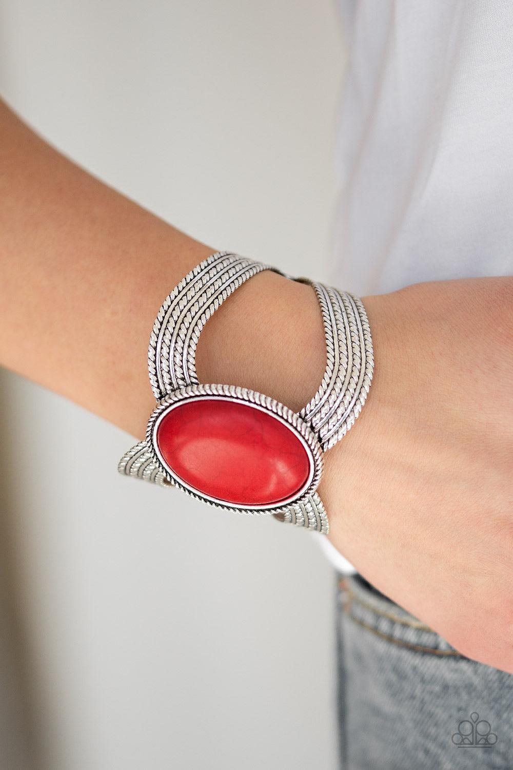 Paparazzi Accessories Coyote Couture - Red A dramatic fiery stone pendant is pressed into the center of textured silver bars, creating a bold seasonal cuff. Jewelry