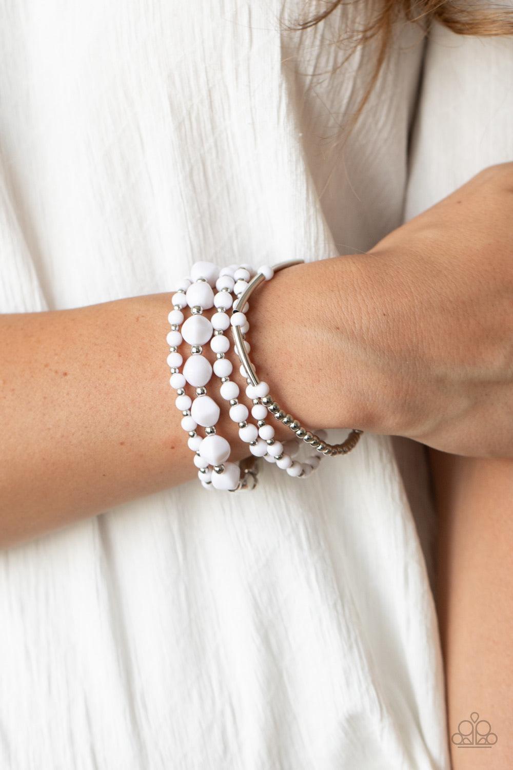Paparazzi Accessories Vibrantly Vintage ~White Infused with dainty silver beads, a mismatched collection of white and shiny silver beads are threaded along stretchy bands around the wrist for a colorfully layered look. Sold as one set of five bracelets.