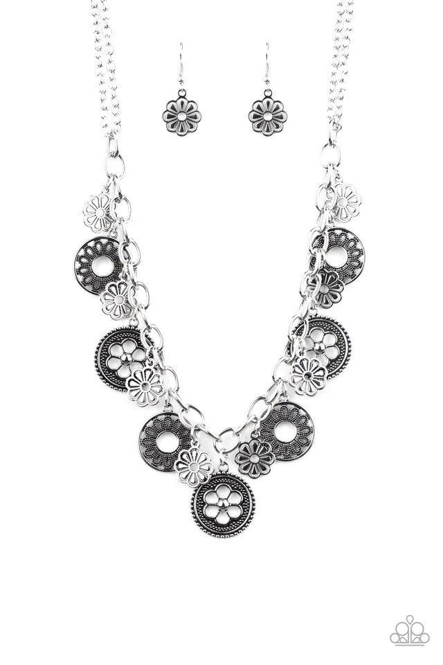 Paparazzi Accessories Meadow Masquerade - Silver A collection of antiqued floral charms dangles from a thick silver chain, creating a whimsical fringe below the collar. Features an adjustable clasp closure.Sold as one individual necklace. Includes one pai