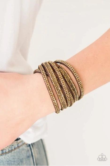 Paparazzi Accessories Rock Star Attitude - Brass Encrusted in rows of glittery aurum rhinestones and flat brass studs, three strands of brown suede wrap around the wrist for a sassy look. The elongated band allows for a trendy double wrap around the wrist