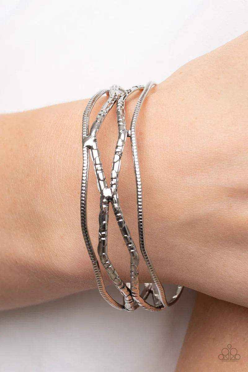 Paparazzi Accessories A Narrow ESCAPADE - Silver Textured and embossed in nature inspired patterns, rustic silver bars zigzag around the wrist as they stack into a wildly layered bangle. Sold as one individual bracelet. Jewelry