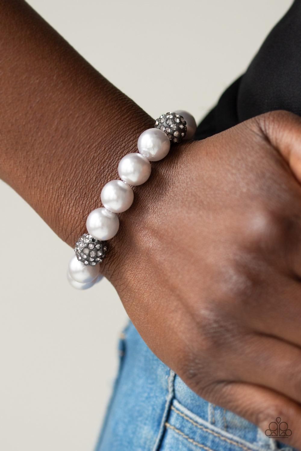 Paparazzi Accessories Cake Walk - Silver A collection of silver pearls and smoky rhinestone encrusted beads are threaded along a stretchy band around the wrist for a refined flair. Sold as one individual bracelet. Jewelry
